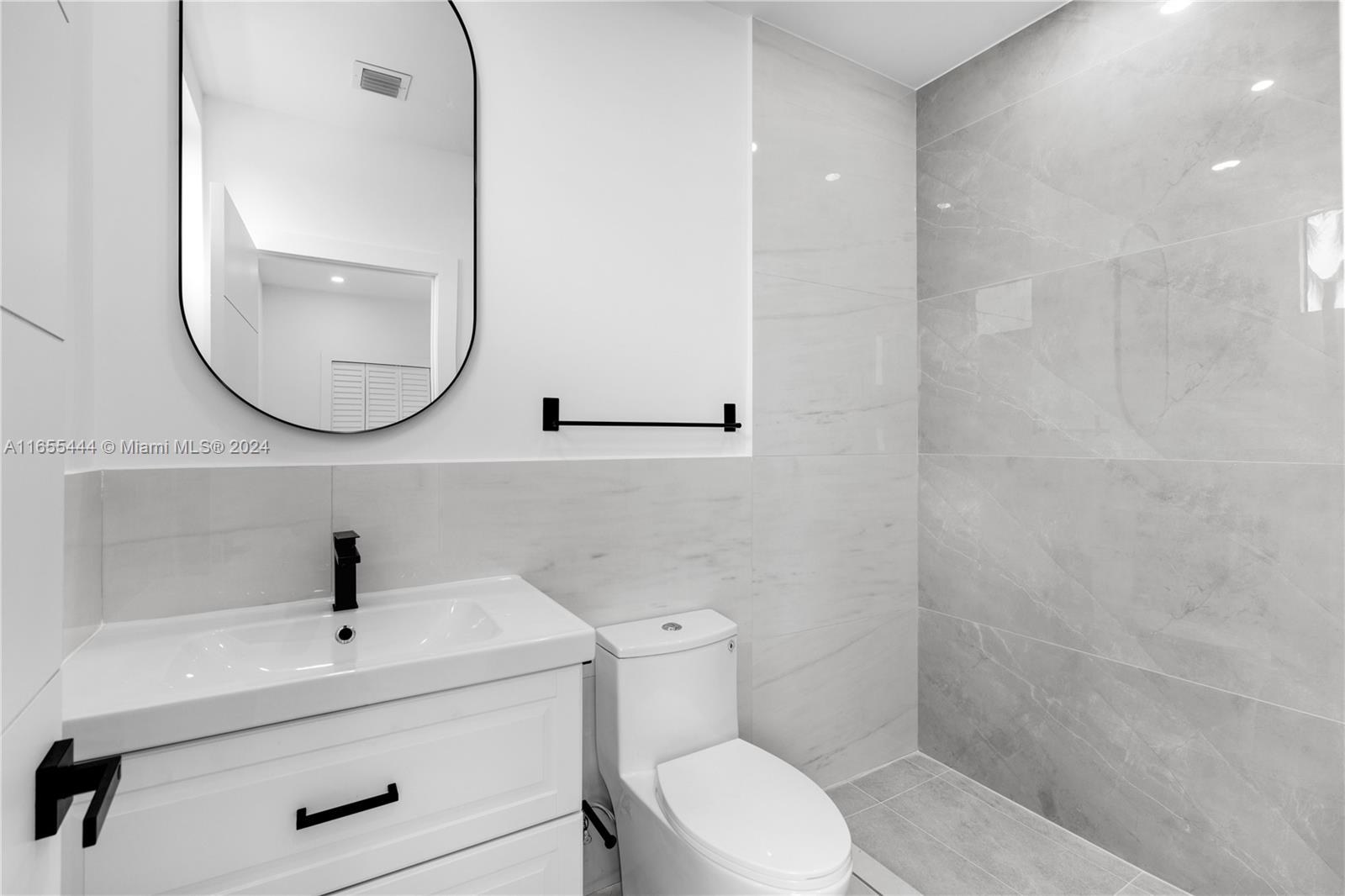2340 Southwest 13th Street, Unit 2340 Miami, FL 33145 - Photo 19 of 26 a bathroom with a sink a toilet and a mirror