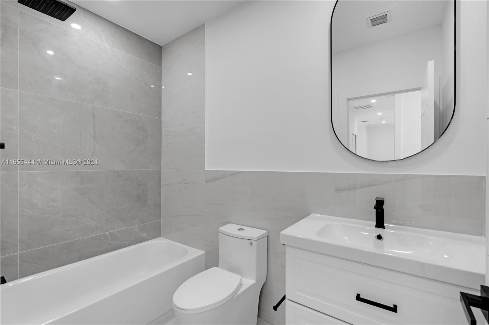 2340 Southwest 13th Street, Unit 2340 Miami, FL 33145 - Photo 22 of 26 a bathroom with a toilet a sink a mirror and bathtub