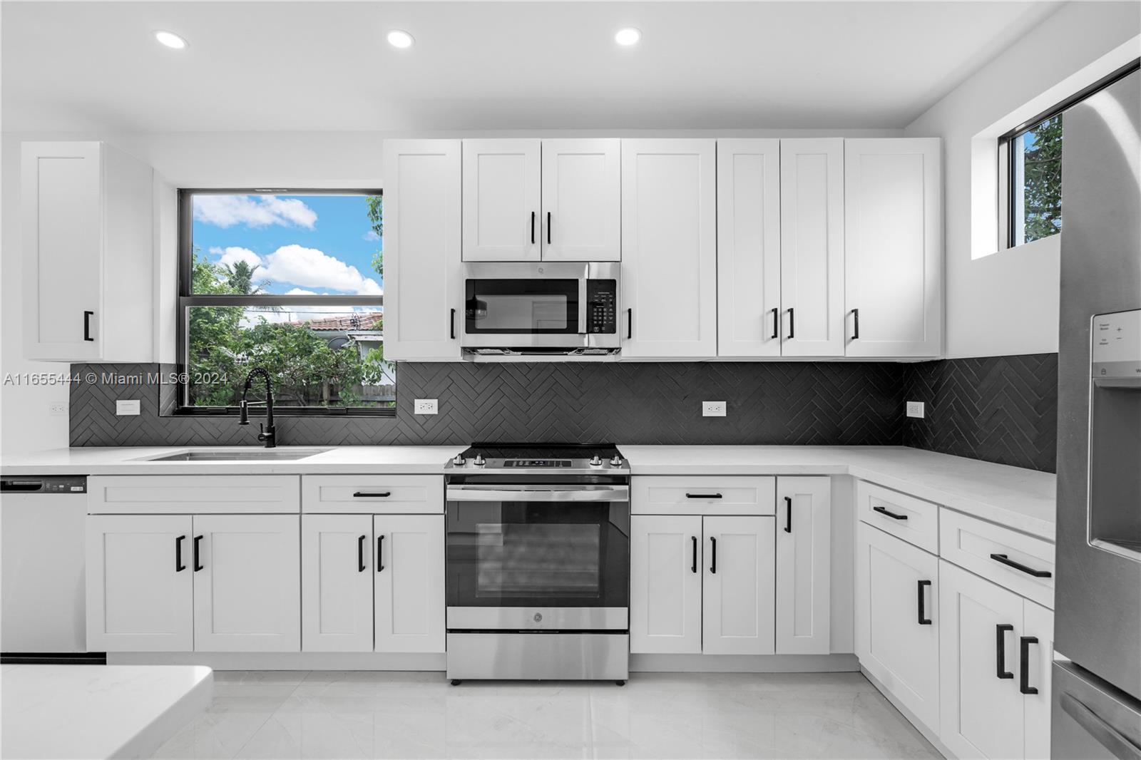 2340 Southwest 13th Street, Unit 2340 Miami, FL 33145 - Photo 5 of 26 a kitchen with white cabinets and white appliances
