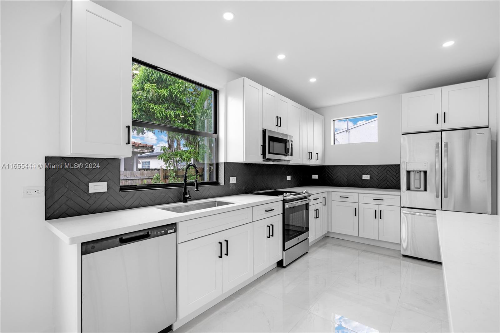2340 Southwest 13th Street, Unit 2340 Miami, FL 33145 - Photo 6 of 26 a kitchen with stainless steel appliances granite countertop a sink and a refrigerator