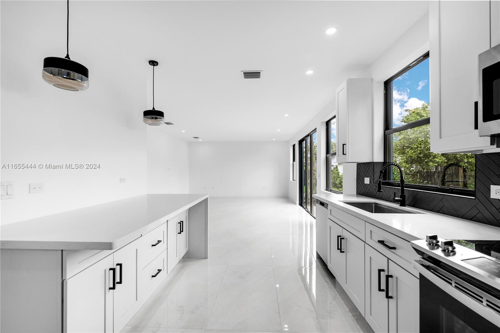 2340 Southwest 13th Street, Unit 2340 Miami, FL 33145 - Photo 7 of 26 a kitchen with stainless steel appliances granite countertop a sink and a stove top oven