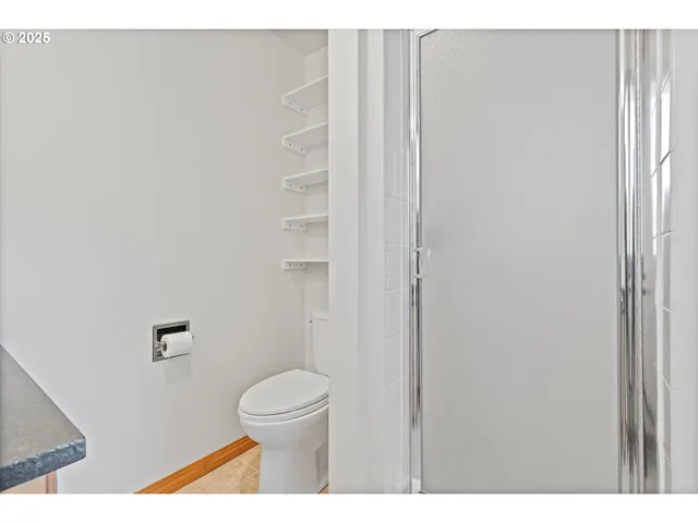 a bathroom with a toilet and a shower