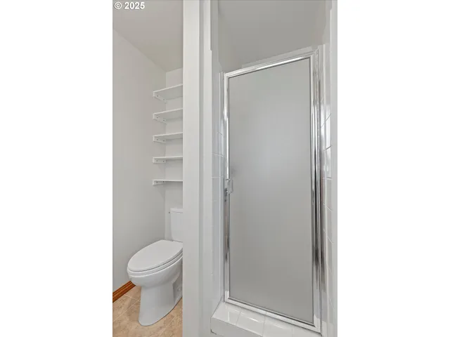 a bathroom with a toilet and a shower