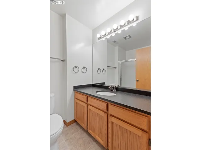 a bathroom with a granite countertop sink a mirror and a shower