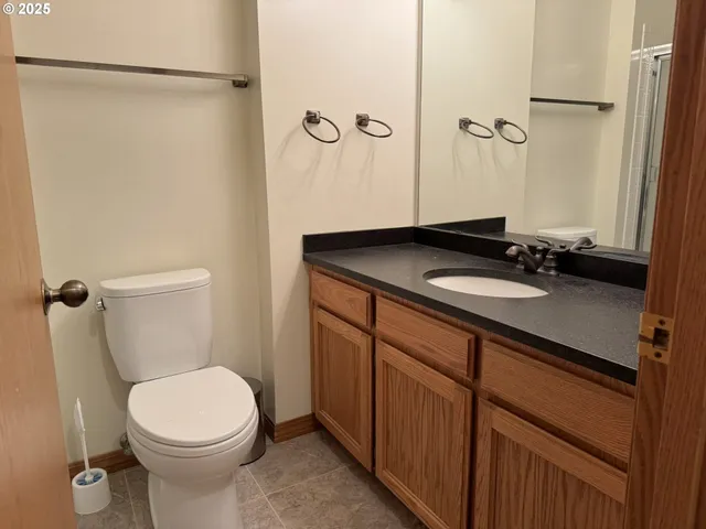 a bathroom with a sink a toilet a mirror and shower