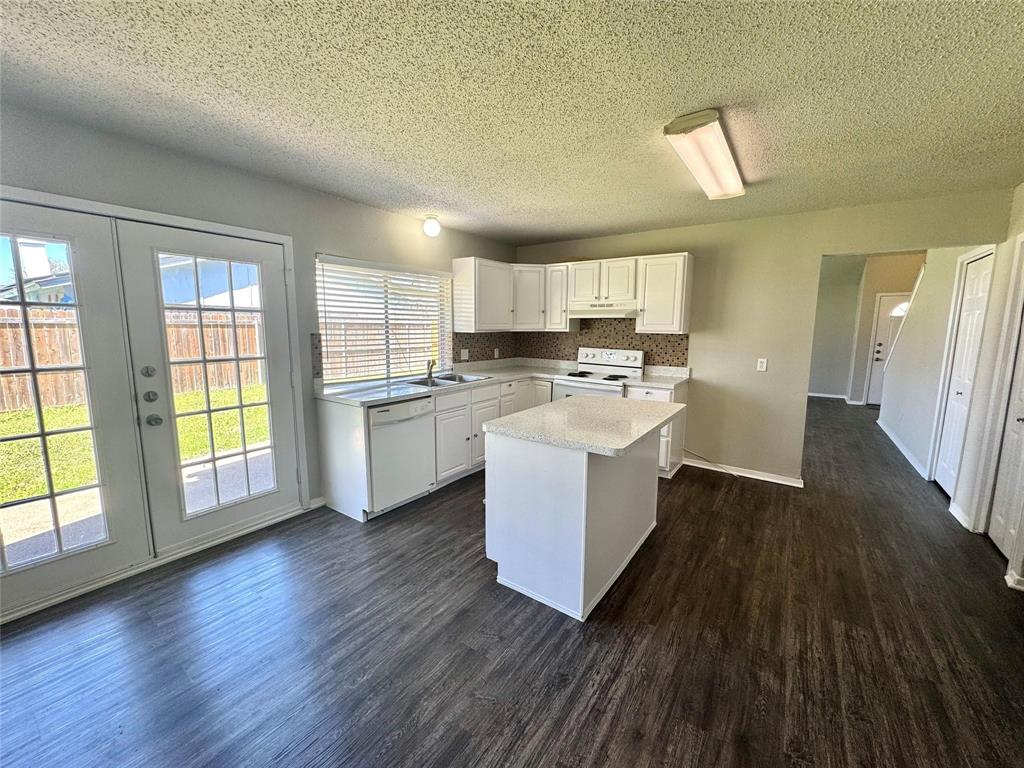 2508 South Center Street Arlington, TX 76014 - Photo 1 of 17 a kitchen with a white stove top oven a refrigerator a sink with wooden cabinets and wooden floor