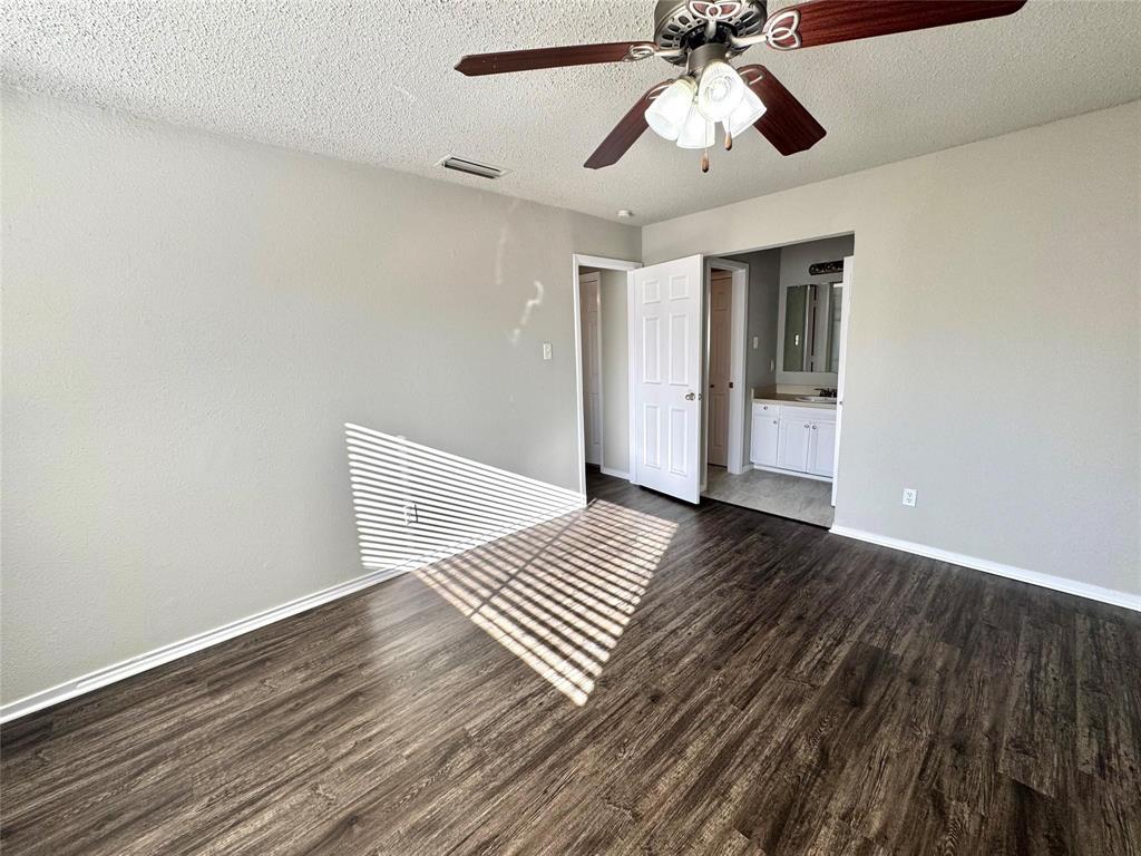 2508 South Center Street Arlington, TX 76014 - Photo 6 of 17 a view of an empty room with wooden floor and a ceiling fan