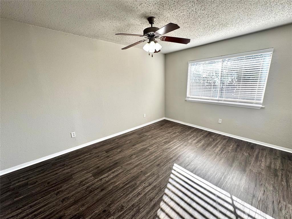 2508 South Center Street Arlington, TX 76014 - Photo 7 of 17 a view of an empty room with a window and wooden floor