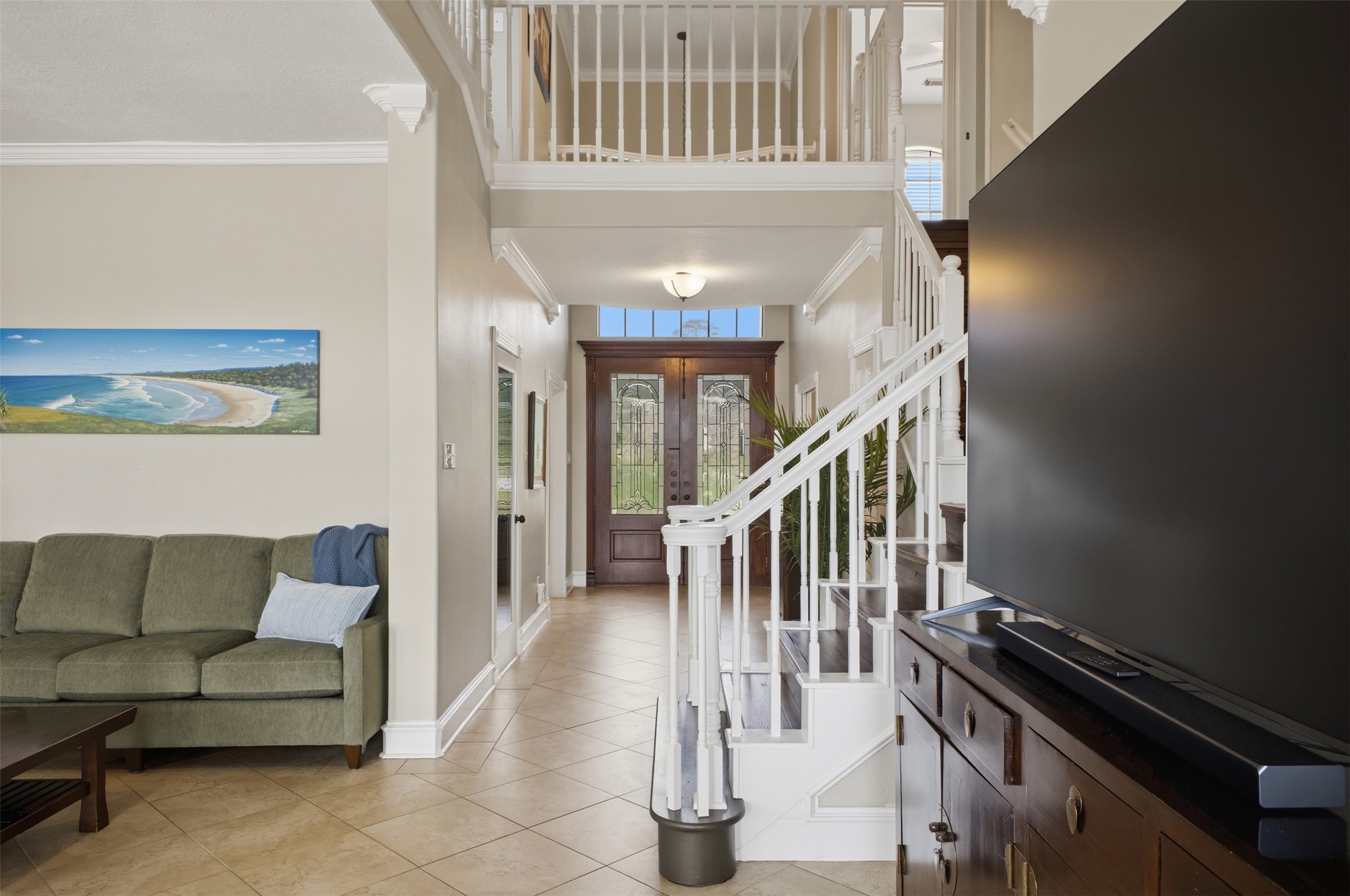 12710 Aries Loop Willis, TX 77318 - Photo 7 of 40 The entry features a wood door with glass inserts, a tiled floor, and a staircase with white railings