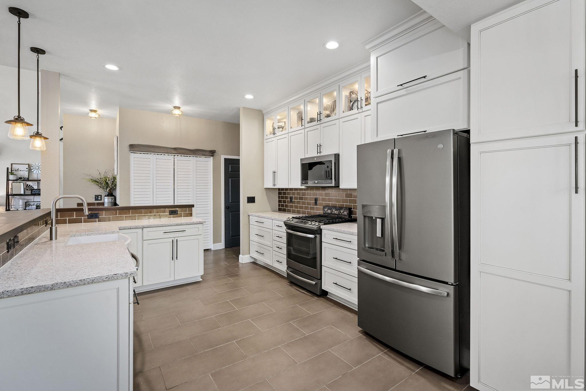 11090 Wagon Ho Lane Reno, NV 89508 - Photo 11 of 33 a kitchen with white cabinets and stainless steel appliances