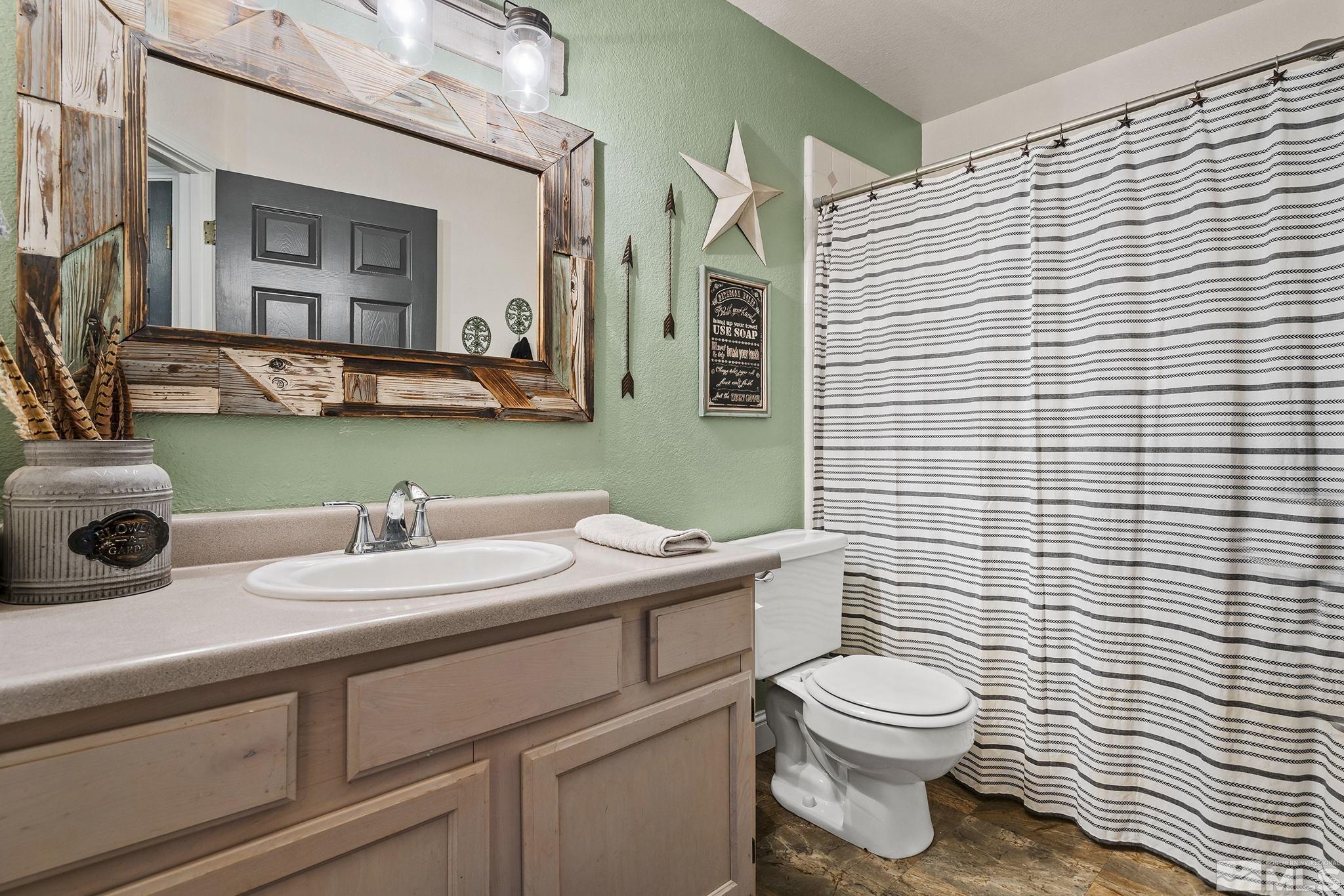 11090 Wagon Ho Lane Reno, NV 89508 - Photo 19 of 33 a bathroom with a toilet a sink and mirror