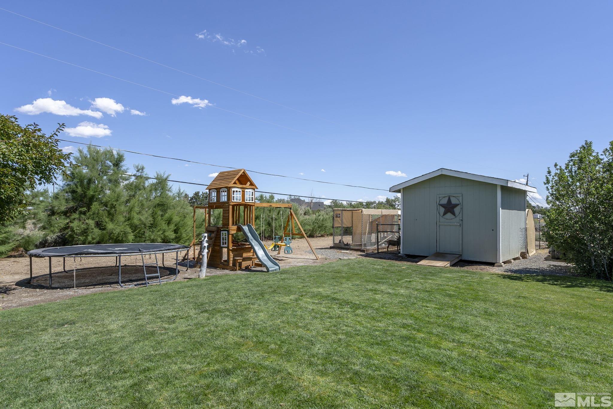 11090 Wagon Ho Lane Reno, NV 89508 - Photo 25 of 33 a view of a backyard with a slide trees and wooden fence