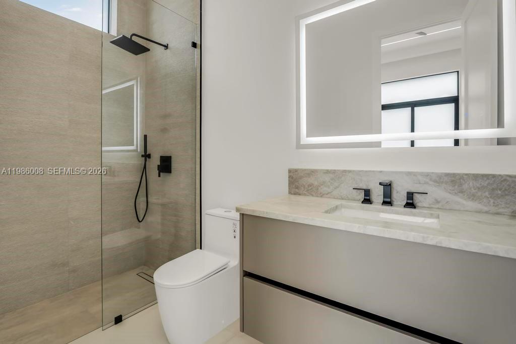 2755 Northeast 31st Court Lighthouse Point, FL 33064 - Photo 12 of 24 a bathroom with a granite countertop sink toilet and shower