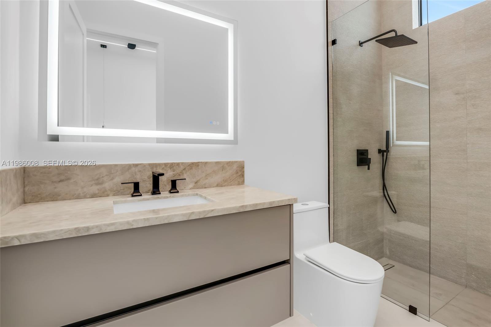 2755 Northeast 31st Court Lighthouse Point, FL 33064 - Photo 14 of 24 a bathroom with a granite countertop sink a toilet and shower