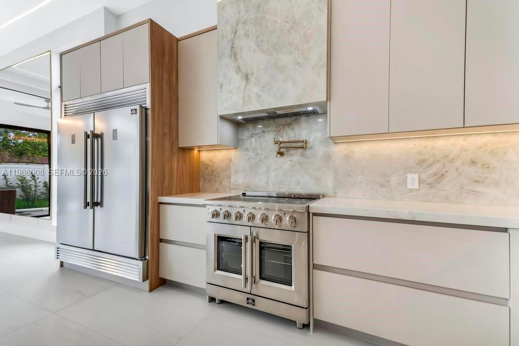 2755 Northeast 31st Court Lighthouse Point, FL 33064 - Photo 6 of 24 a kitchen with granite countertop white cabinets and white stainless steel appliances