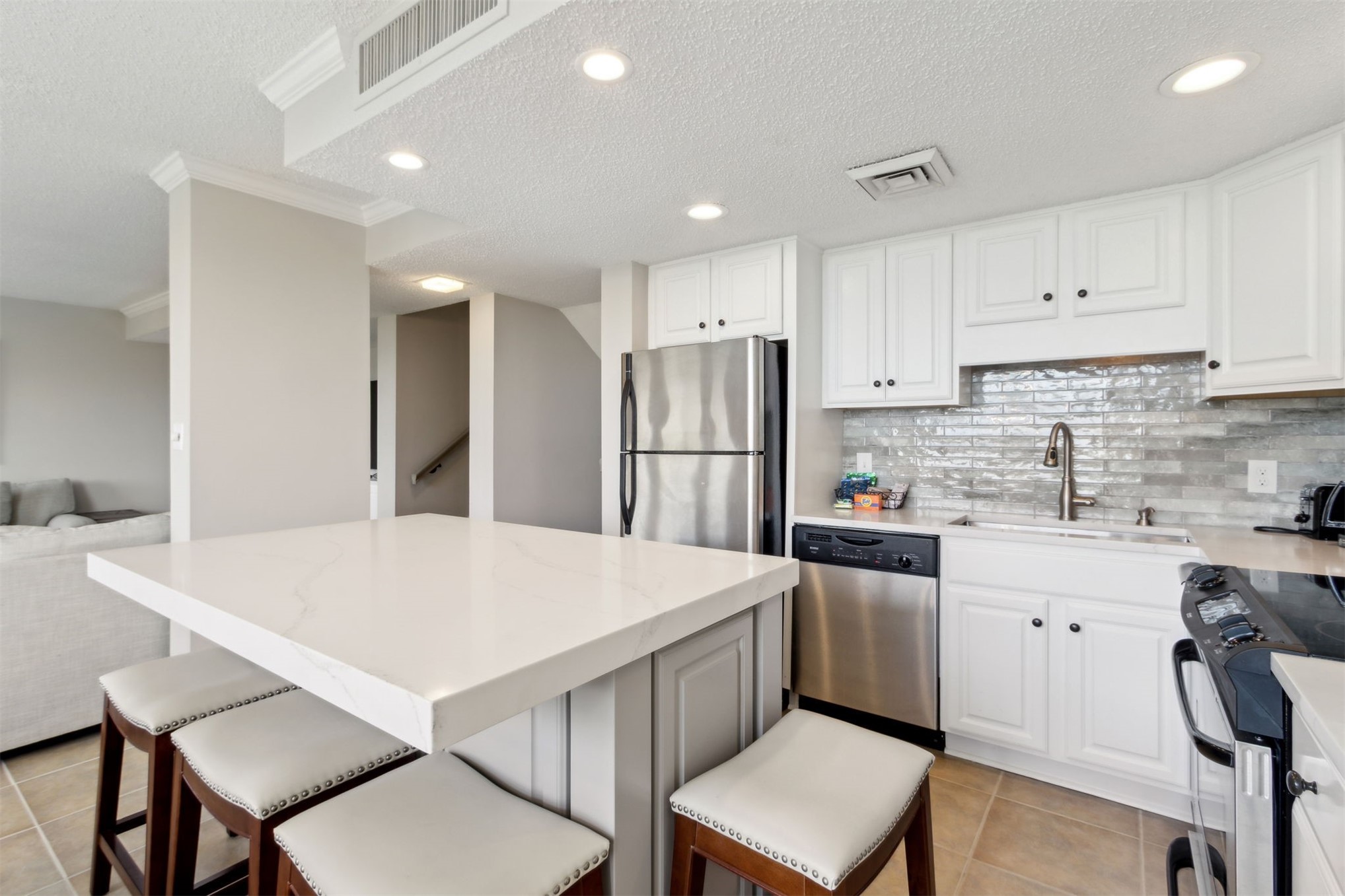 1165 Beach Walker Road, Unit 1165 Fernandina Beach, FL 32034 - Photo 13 of 45 a kitchen with stainless steel appliances a refrigerator sink and white cabinets