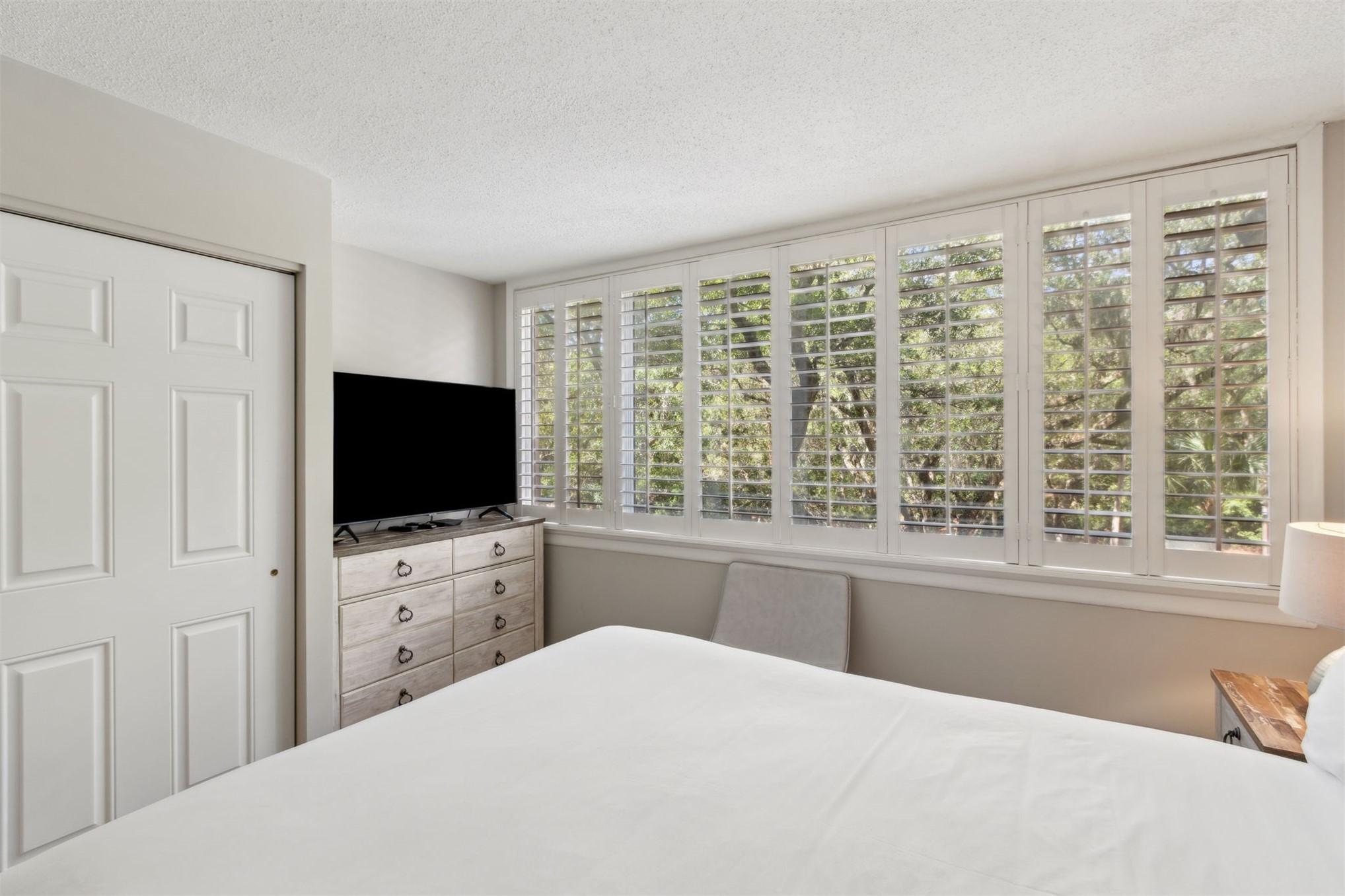 1165 Beach Walker Road, Unit 1165 Fernandina Beach, FL 32034 - Photo 16 of 45 a bedroom with a large bed and a flat tv screen on a dresser