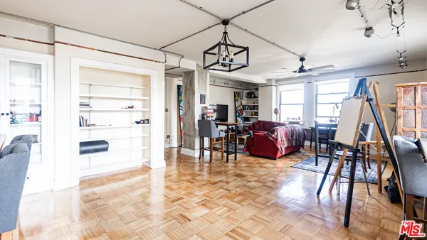 a living room with furniture a wooden floor and next to a window