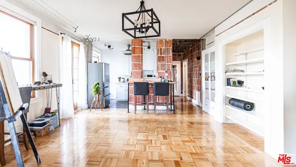 a dining room with stainless steel appliances a table chairs and chandelier