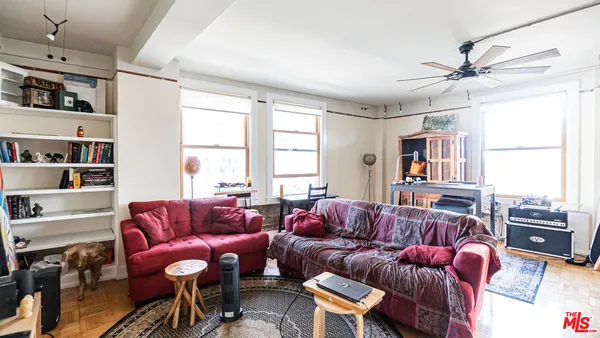 a living room with furniture a flat screen tv and a window