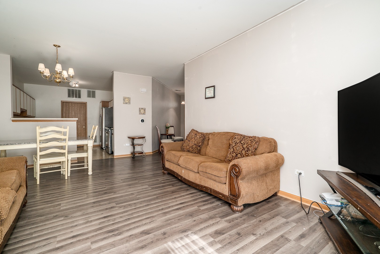 24100 Pear Tree Circle Plainfield, IL 60585 - Photo 4 of 13 a living room with furniture a flat screen tv and wooden floor