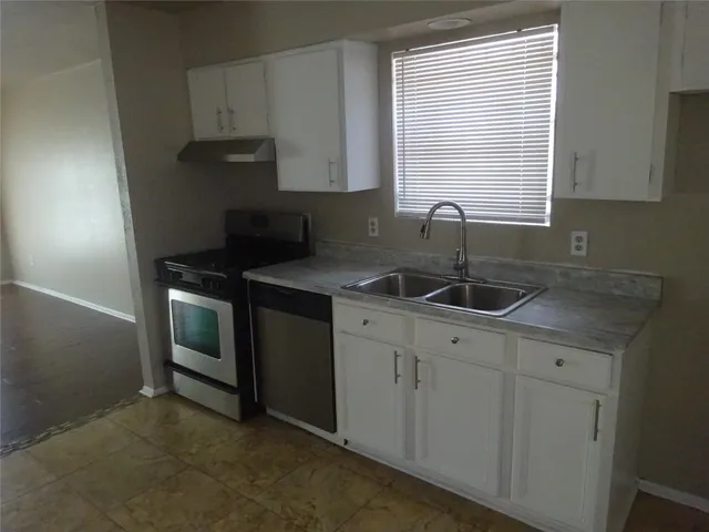 a kitchen with a sink cabinets and window