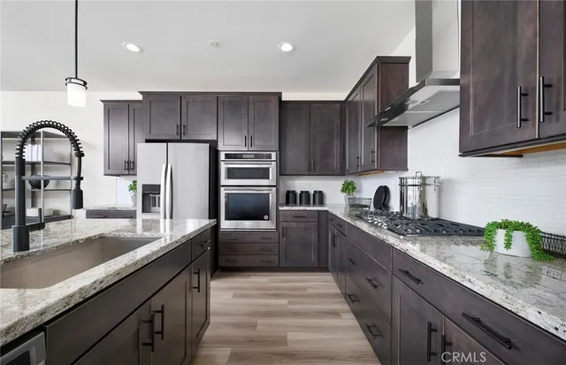 a kitchen with kitchen island granite countertop a sink stainless steel appliances and cabinets