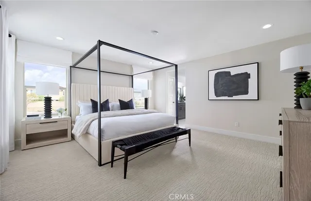 a bedroom with a bed lamp and paintings on the wall