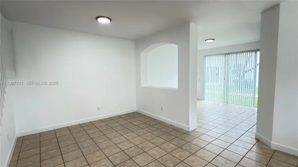 a view of a hallway with wooden floor and a bathroom