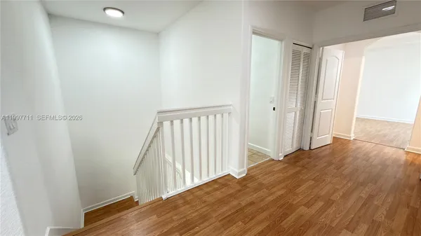 an empty room with wooden floor and a window