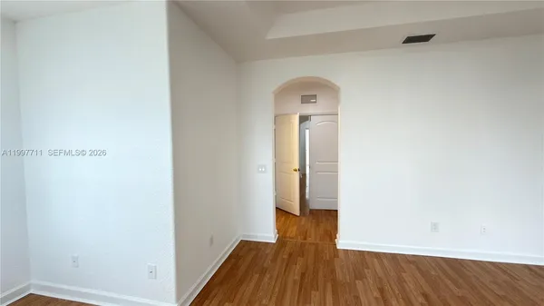 a view of empty room with wooden floor