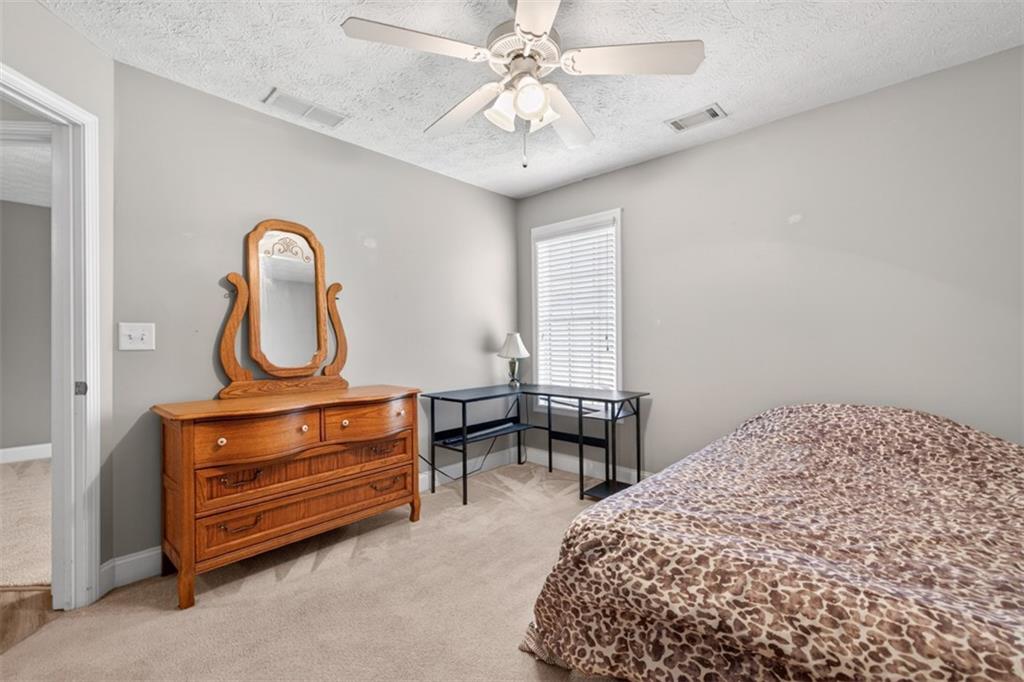 89 Katie Spring Lane Jefferson, GA 30549 - Photo 31 of 63 a bedroom with bed and a chandelier