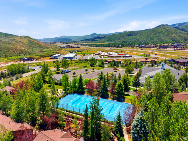 3148 Lower Saddleback Road Park City, UT 84098 - Photo 66 of 67 Outdoor tennis court with a bright blue playing surface, surrounded by mature trees and lush green landscaping