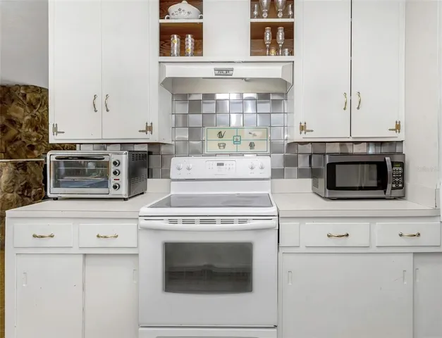 a kitchen that has a sink and white cabinets