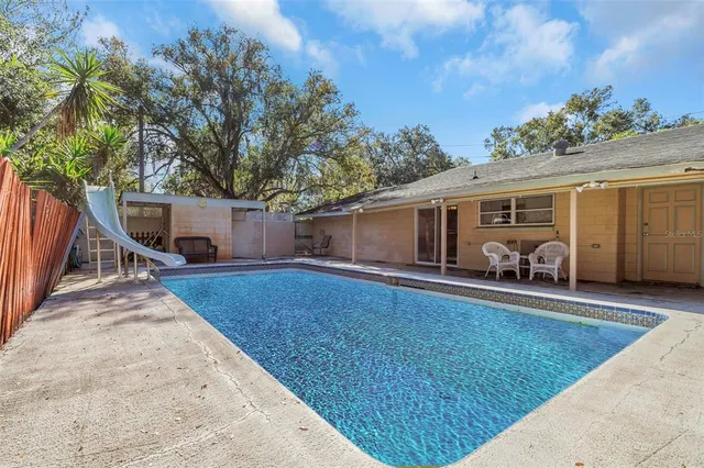a view of backyard with wooden fence and large trees
