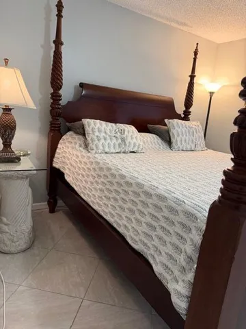 a bed sitting in a bedroom next to a lamp