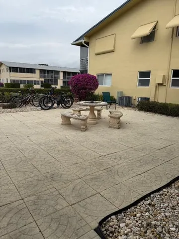 a view of a patio with dining table and chairs with wooden fence