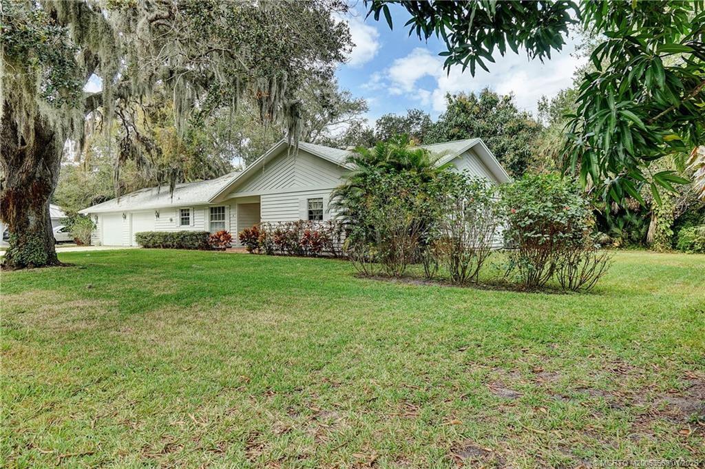 4 Miramar Road Sewall's Point, FL 34996 - Photo 7 of 31 a view of a house next to a big yard and large trees