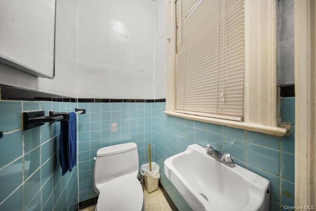 41-71 Gleane Street Queens, NY 11373 - Photo 8 of 28 a bathroom with a sink a toilet and a mirror