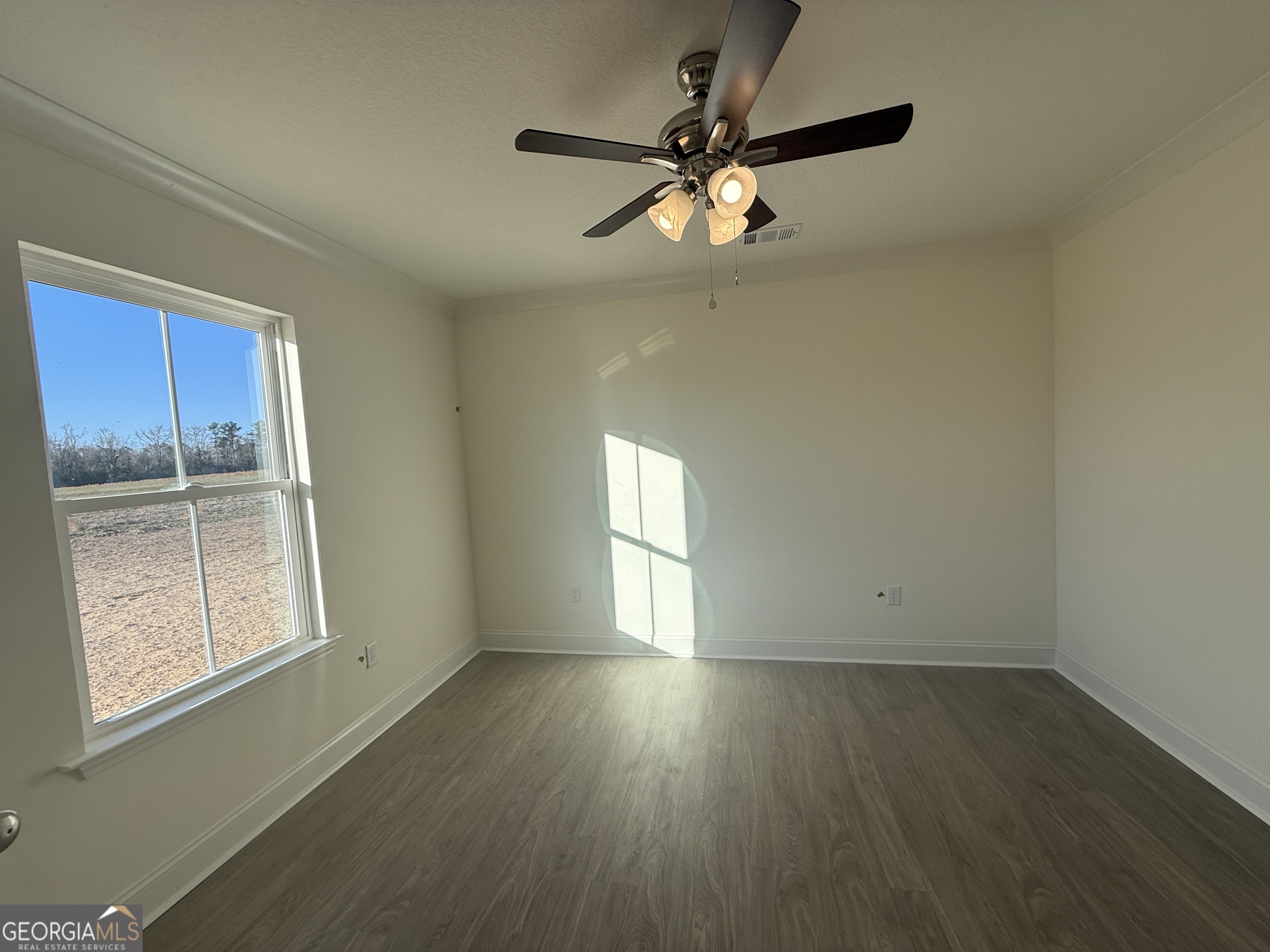 304 Womack Road South Portal, GA 30450 - Photo 15 of 19 an empty room with wooden floor fan and windows