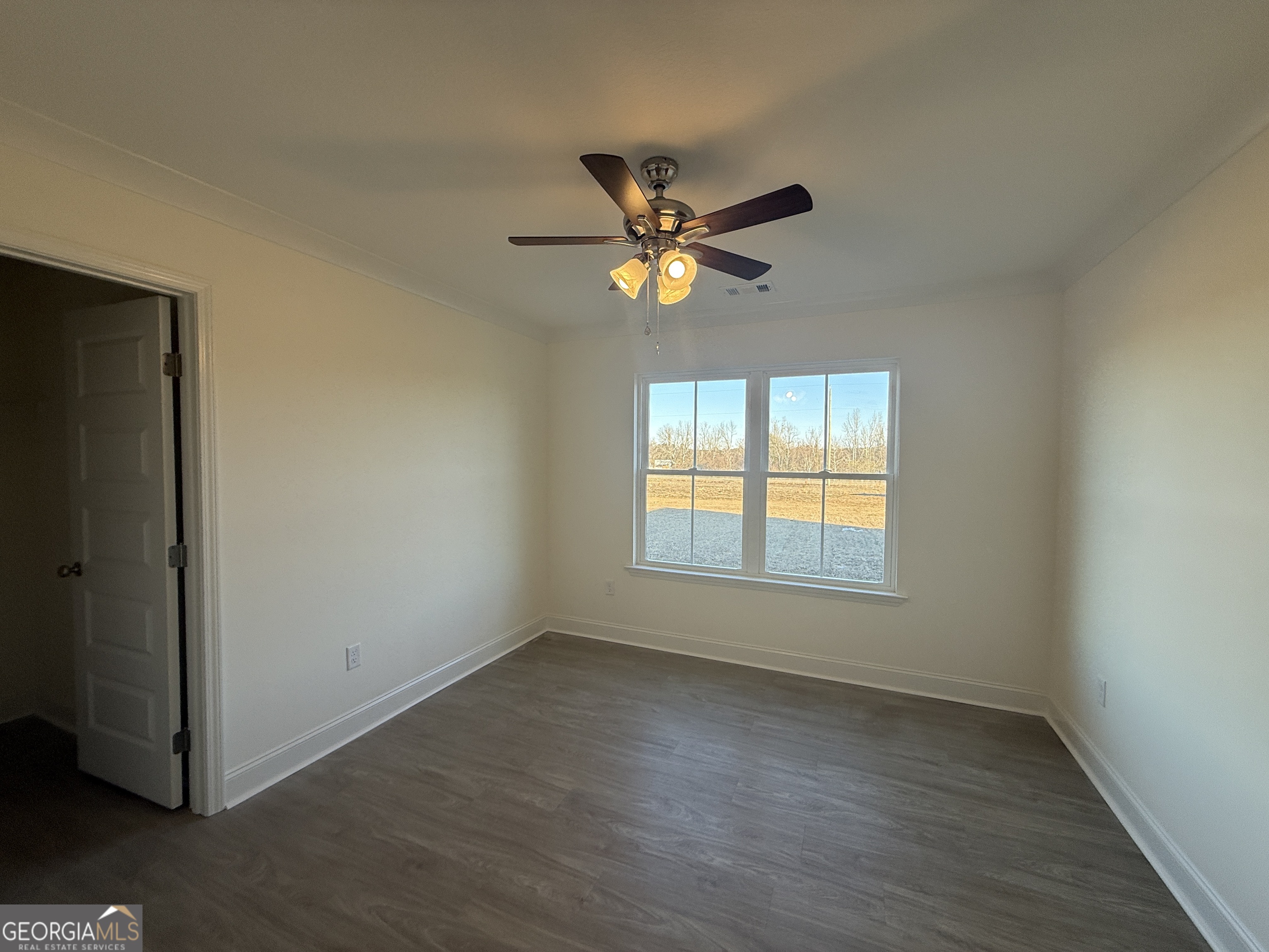 304 Womack Road South Portal, GA 30450 - Photo 17 of 19 an empty room with a window and a fan