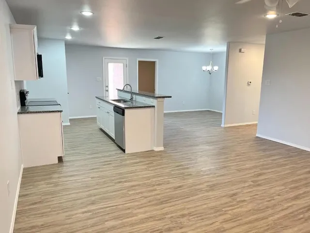 a kitchen with granite countertop a stove and a wooden floor