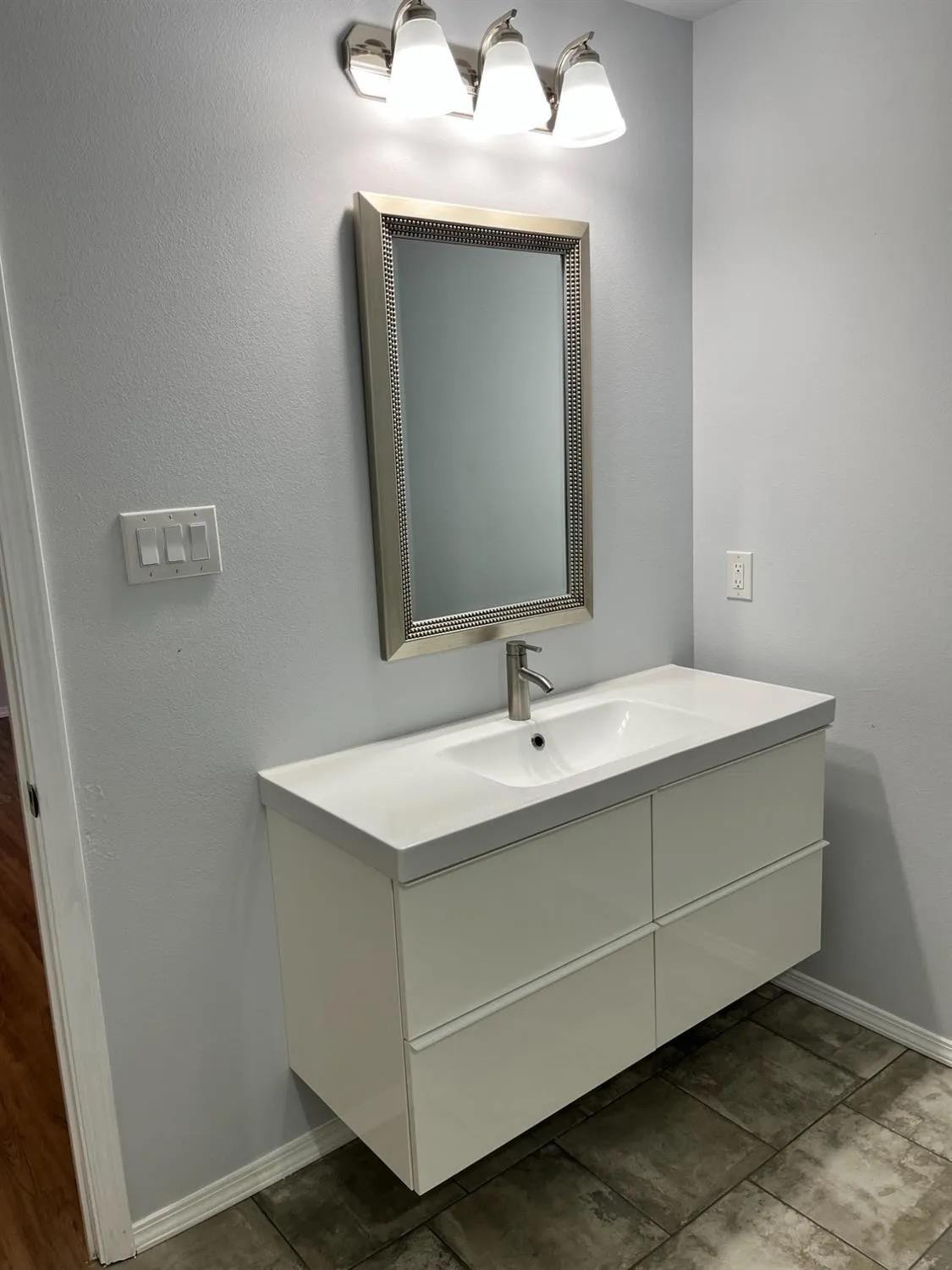 8423 10th Place Lubbock, TX 79416 - Photo 6 of 13 a bathroom with a sink and a mirror