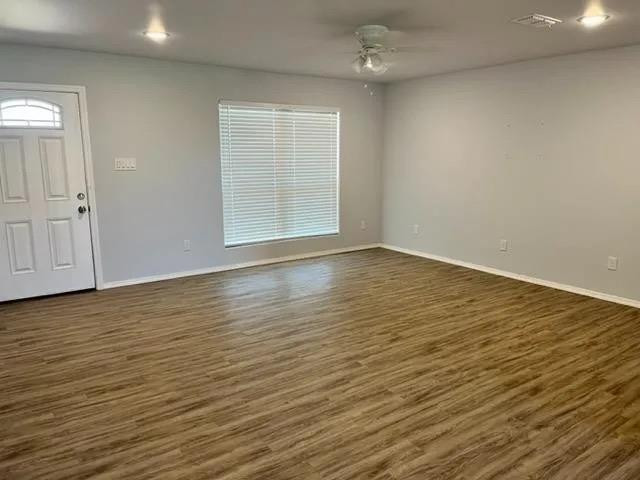 8423 10th Place Lubbock, TX 79416 - Photo 9 of 13 a view of an empty room with wooden floor and a window