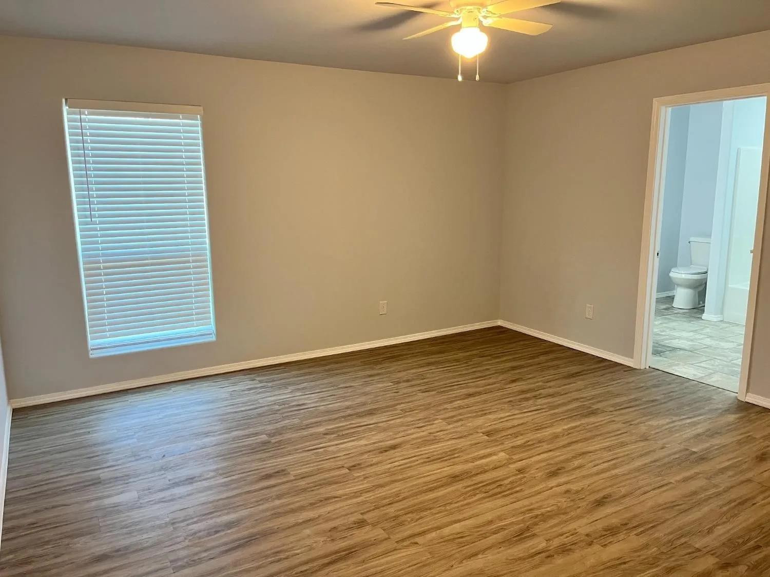 8423 10th Place Lubbock, TX 79416 - Photo 10 of 13 a view of an empty room with wooden floor and a window