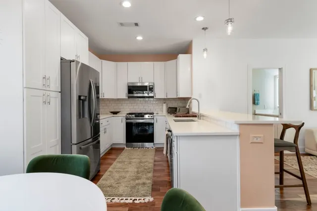 a kitchen with stainless steel appliances a stove refrigerator sink and microwave