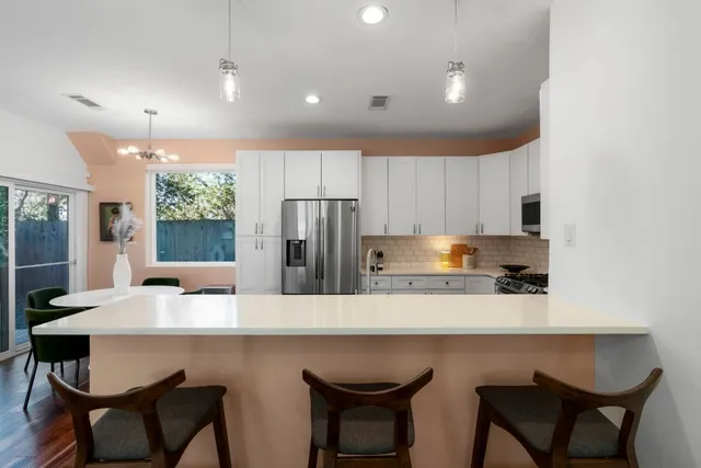 a kitchen with stainless steel appliances a dining table and chairs