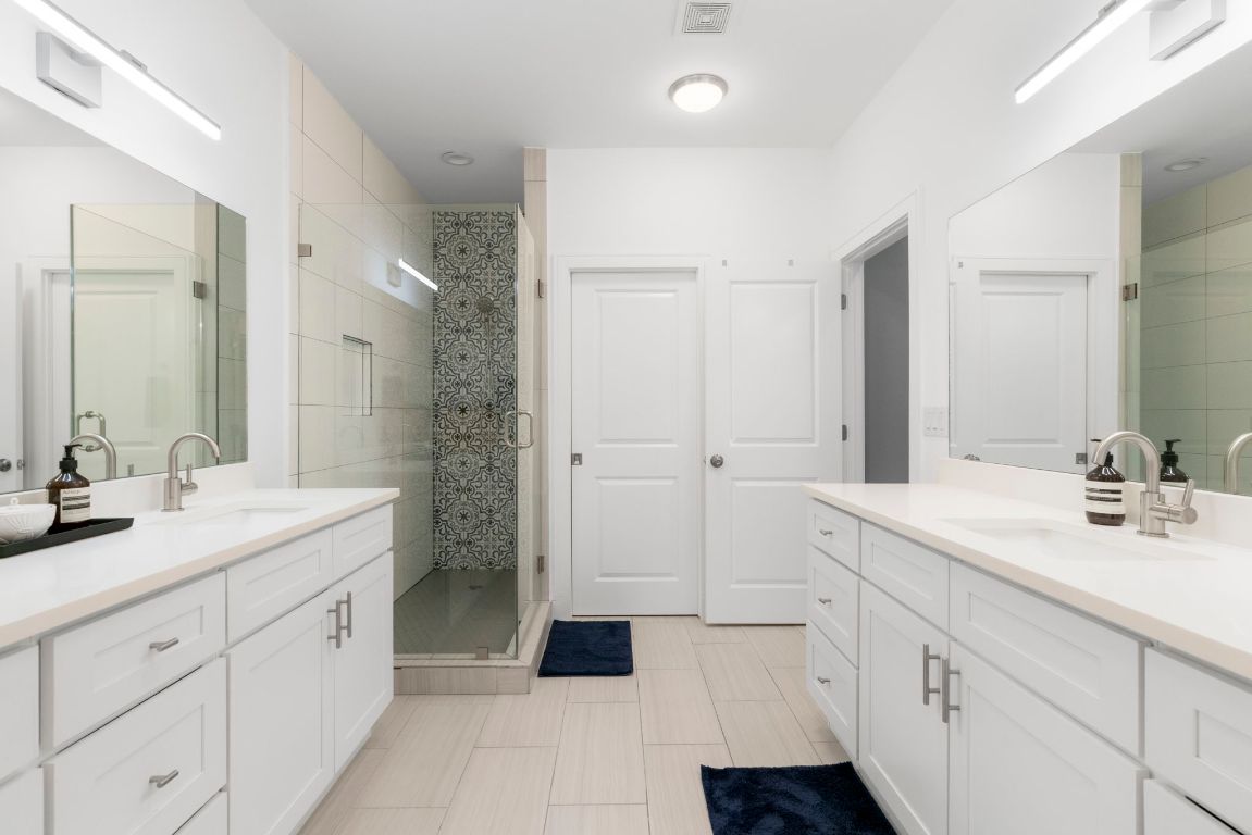 1148 Webberville Road, Unit 6 Austin, TX 78721 - Photo 21 of 34 a spacious bathroom with a double vanity sink a mirror a shower and a bathtub