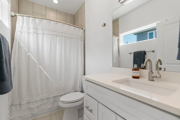 a bathroom with a sink a toilet and a mirror