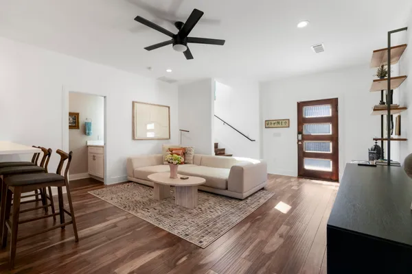 a living room with furniture and a wooden floor
